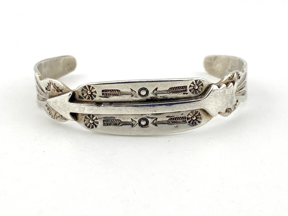Vintage 1920s–1930s Navajo Fred Harvey era silver cuff bracelet with applied arrows, hand stamped motifs, and lizard-like markings.