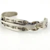 Vintage 1920s–1930s Navajo Fred Harvey era silver cuff bracelet with applied arrows, hand stamped motifs, and lizard-like markings.