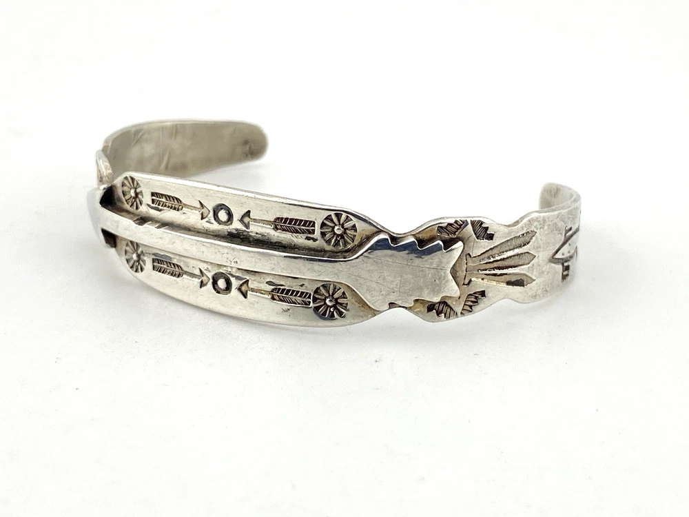 Vintage 1920s–1930s Navajo Fred Harvey era silver cuff bracelet with applied arrows, hand stamped motifs, and lizard-like markings.