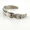 Vintage 1920s–1930s Navajo Fred Harvey era silver cuff bracelet with applied arrows, hand stamped motifs, and lizard-like markings.