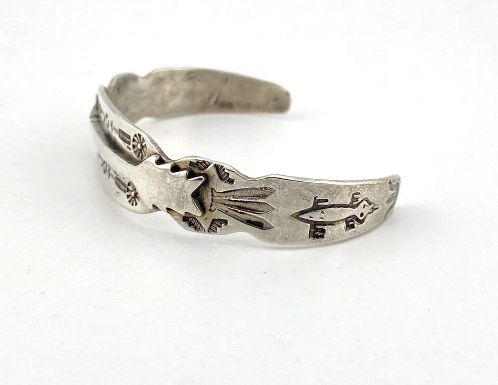 Vintage 1920s–1930s Navajo Fred Harvey era silver cuff bracelet with applied arrows, hand stamped motifs, and lizard-like markings.