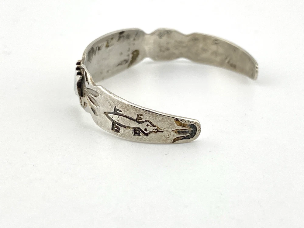 Vintage 1920s–1930s Navajo Fred Harvey era silver cuff bracelet with applied arrows, hand stamped motifs, and lizard-like markings.