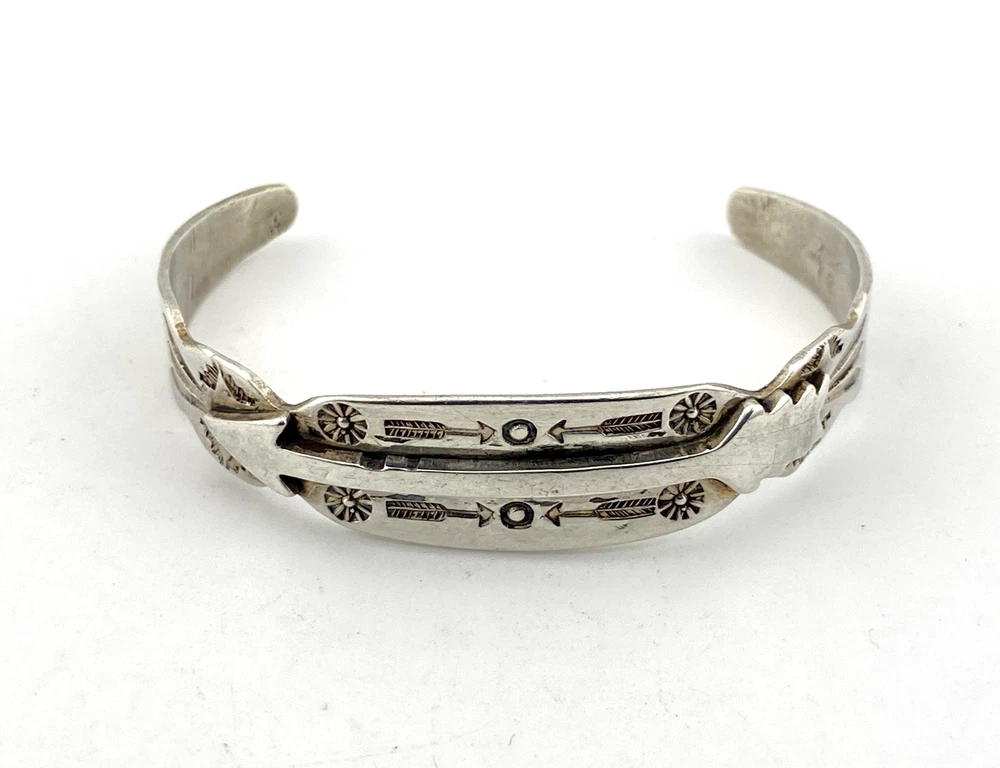 Vintage 1920s–1930s Navajo Fred Harvey era silver cuff bracelet with applied arrows, hand stamped motifs, and lizard-like markings.