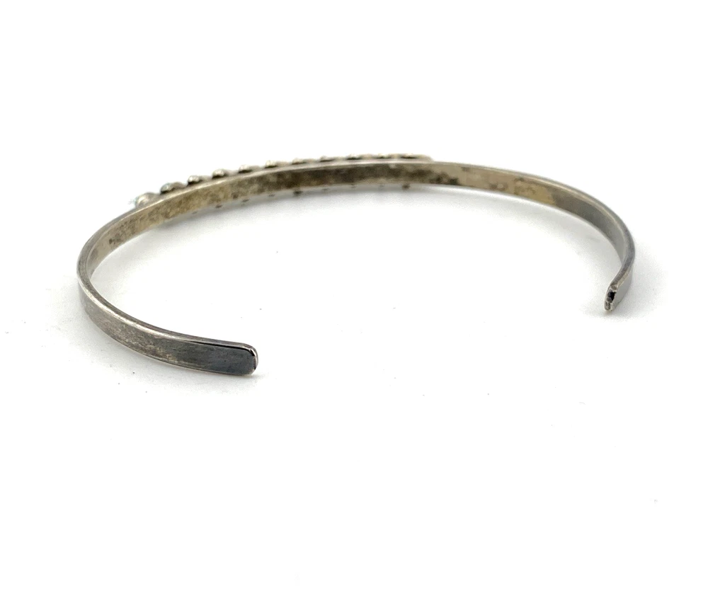 Vintage sterling silver cuff bracelet with eleven small turquoise snake-eye cabochons.