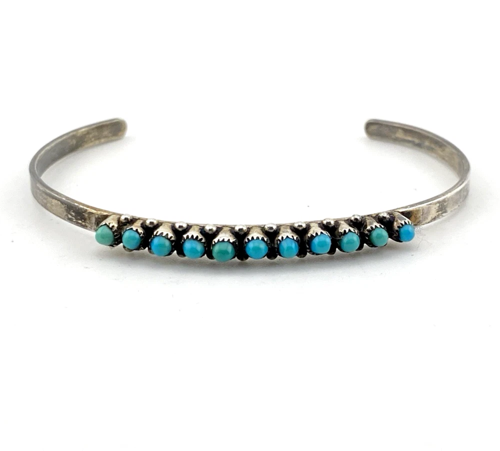 Vintage sterling silver cuff bracelet with eleven small turquoise snake-eye cabochons.