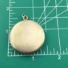 Vintage 1940s sterling silver round family locket by L&M with matte covers, gold washed interior, patent applied for mark, and multiple photo compartments