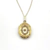 Vintage F.M. Co 1/20 10K gold filled oval locket necklace with hand engraved floral center, raised frame, and 19.5 inch chain