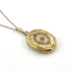 Vintage F.M. Co 1/20 10K gold filled oval locket necklace with hand engraved floral center, raised frame, and 19.5 inch chain