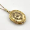 Vintage F.M. Co 1/20 10K gold filled oval locket necklace with hand engraved floral center, raised frame, and 19.5 inch chain