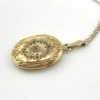 Vintage F.M. Co 1/20 10K gold filled oval locket necklace with hand engraved floral center, raised frame, and 19.5 inch chain