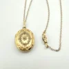 Vintage F.M. Co 1/20 10K gold filled oval locket necklace with hand engraved floral center, raised frame, and 19.5 inch chain