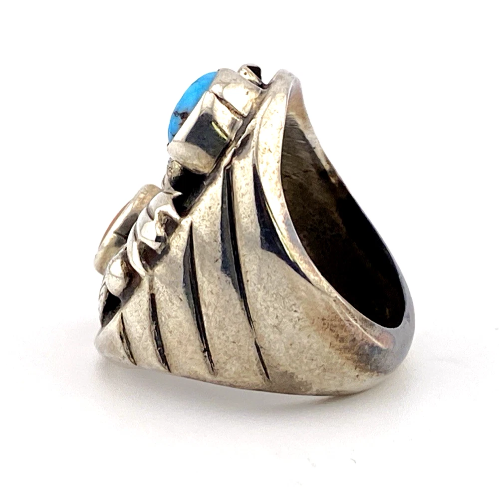 Vintage old pawn style sterling silver ring with turquoise and coral cabochons, raised silver details, and dark patina.