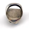 Vintage old pawn style sterling silver ring with turquoise and coral cabochons, raised silver details, and dark patina.