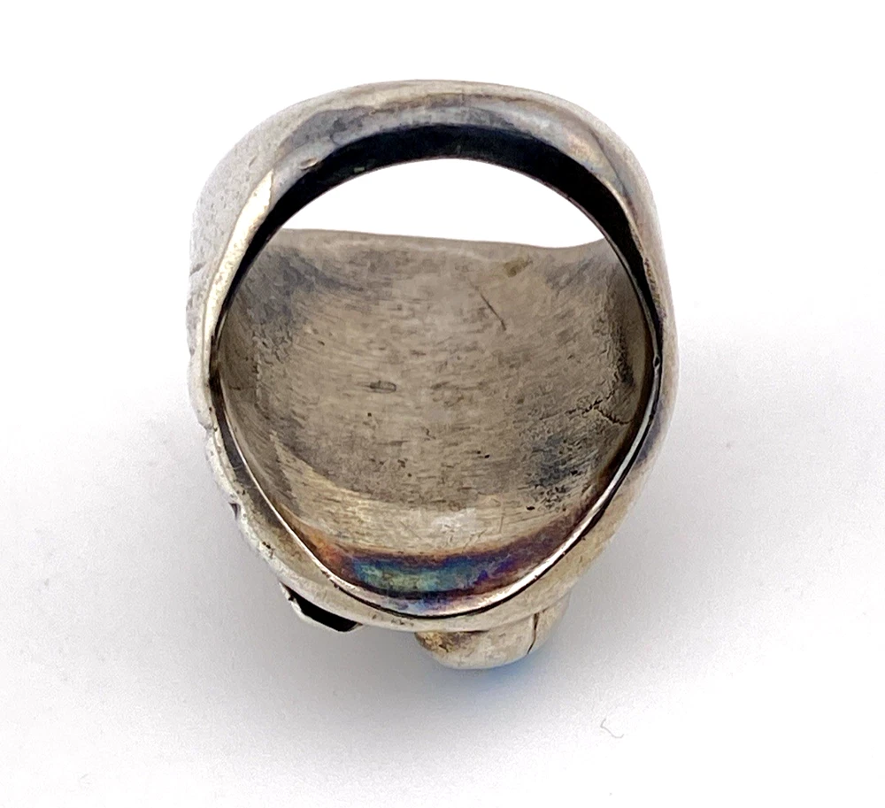 Vintage old pawn style sterling silver ring with turquoise and coral cabochons, raised silver details, and dark patina.