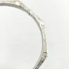 Vintage sterling silver octagonal hinged bangle bracelet with engraved details and safety chain.