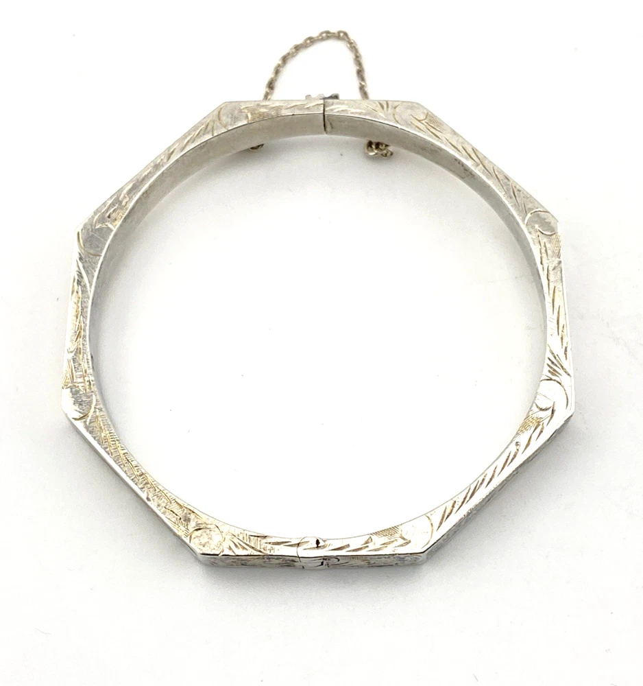 Vintage sterling silver octagonal hinged bangle bracelet with engraved details and safety chain.