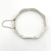Vintage sterling silver octagonal hinged bangle bracelet with engraved details and safety chain.