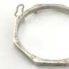 Vintage sterling silver octagonal hinged bangle bracelet with engraved details and safety chain.