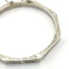 Vintage sterling silver octagonal hinged bangle bracelet with engraved details and safety chain.
