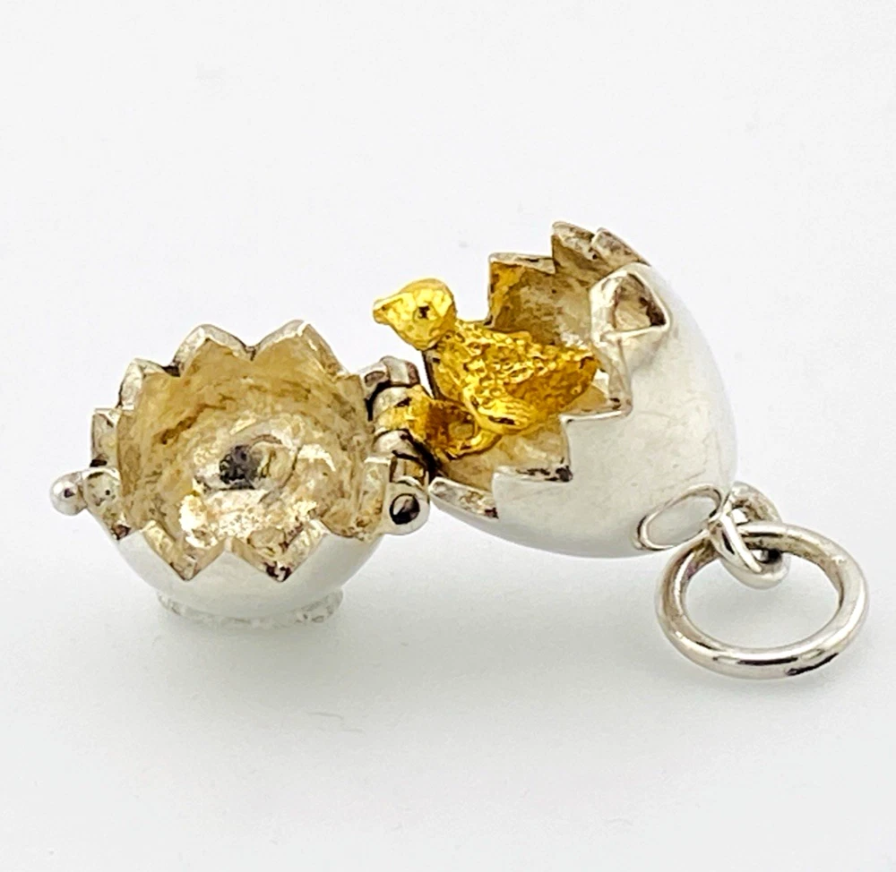 Vintage sterling silver hinged egg pendant charm that opens to reveal a gold vermeil chick inside.