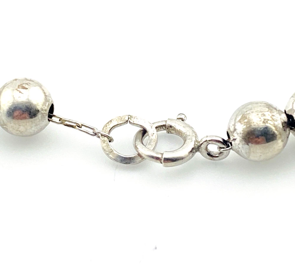 The silver beads are individually strung on a foxtail-style chain