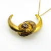Antique Victorian crescent moon brooch converted into a pendant necklace with a faceted glass stone, enamel accents, and an 18¼-inch gold filled chain.
