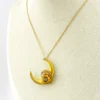 Antique Victorian crescent moon brooch converted into a pendant necklace with a faceted glass stone, enamel accents, and an 18¼-inch gold filled chain.