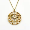 Antique Edwardian round openwork pendant necklace in warm rose gold filled with a likely natural pearl center on a 16-inch chain.