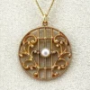 Antique Edwardian round openwork pendant necklace in warm rose gold filled with a likely natural pearl center on a 16-inch chain.