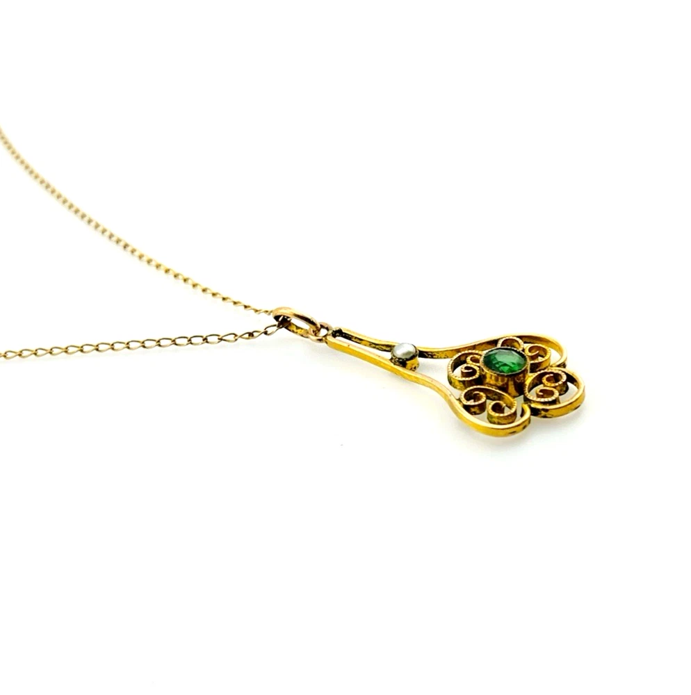 Vintage lavaliere pendant necklace with a faceted green glass stone, genuine pearl accent, and 12K gold filled chain.