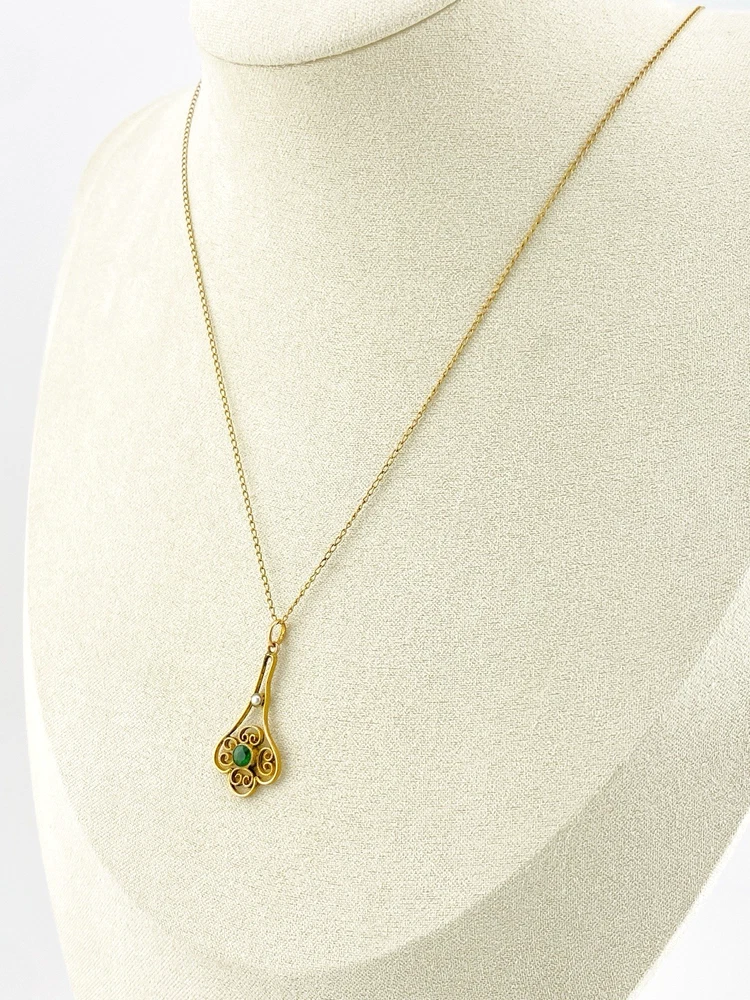 Vintage lavaliere pendant necklace with a faceted green glass stone, genuine pearl accent, and 12K gold filled chain.