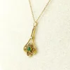 Vintage lavaliere pendant necklace with a faceted green glass stone, genuine pearl accent, and 12K gold filled chain.