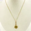 Vintage lavaliere pendant necklace with a faceted green glass stone, genuine pearl accent, and 12K gold filled chain.