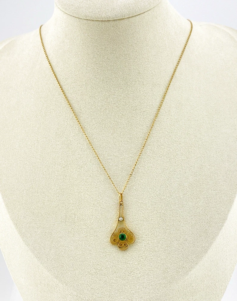 Vintage lavaliere pendant necklace with a faceted green glass stone, genuine pearl accent, and 12K gold filled chain.
