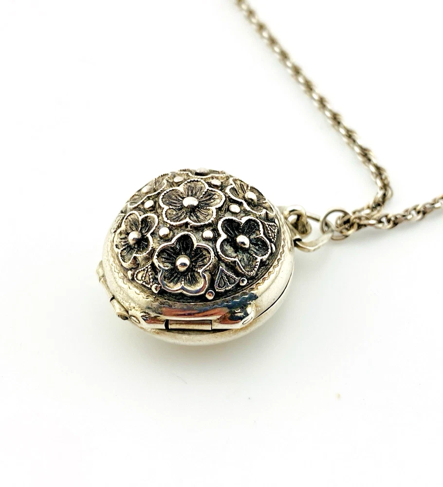 WWII-era sterling silver forget-me-not locket opened to reveal four original family photographs