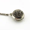 WWII-era sterling silver forget-me-not locket opened to reveal four original family photographs