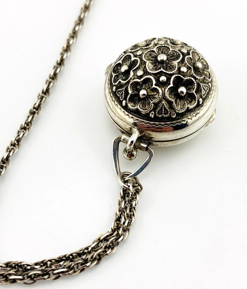 WWII-era sterling silver forget-me-not locket opened to reveal four original family photographs