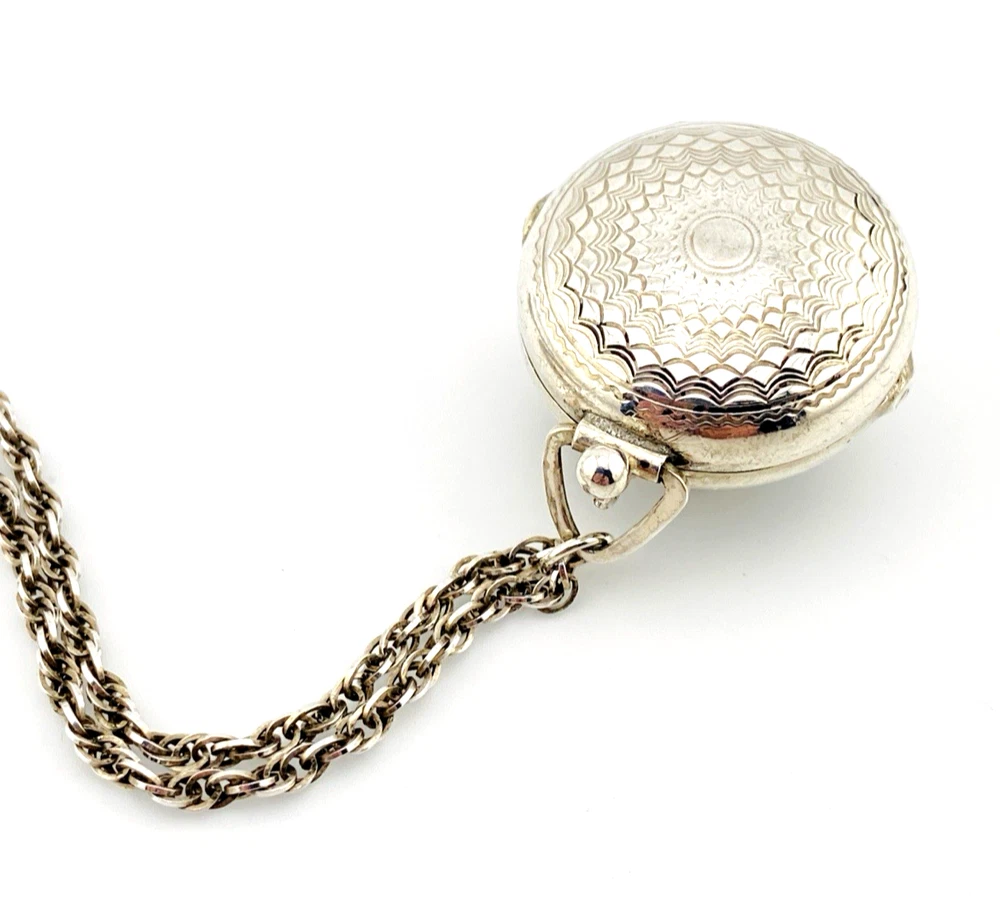 WWII-era sterling silver forget-me-not locket opened to reveal four original family photographs