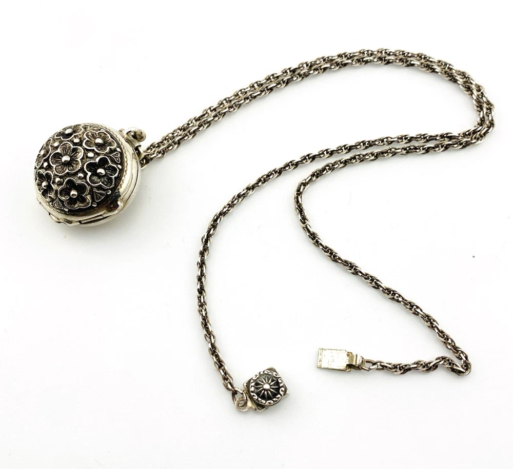 WWII-era sterling silver forget-me-not locket opened to reveal four original family photographs