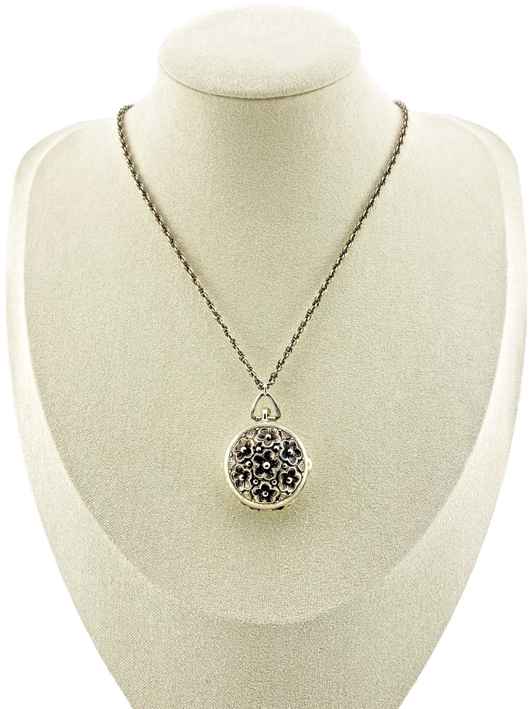 WWII-era sterling silver forget-me-not locket opened to reveal four original family photographs