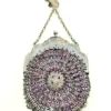 Antique silver-colored chatelaine purse with openwork metal, purple silk lining, fringe, and fleur-de-lis belt clip