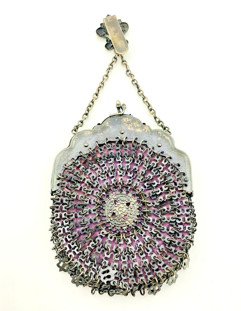 Antique silver-colored chatelaine purse with openwork metal, purple silk lining, fringe, and fleur-de-lis belt clip