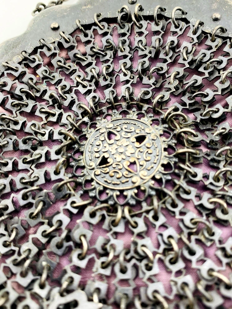 Antique silver-colored chatelaine purse with openwork metal, purple silk lining, fringe, and fleur-de-lis belt clip