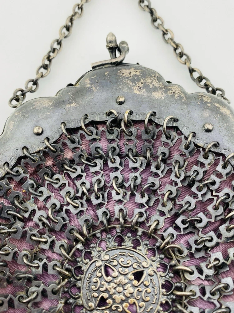 Antique silver-colored chatelaine purse with openwork metal, purple silk lining, fringe, and fleur-de-lis belt clip