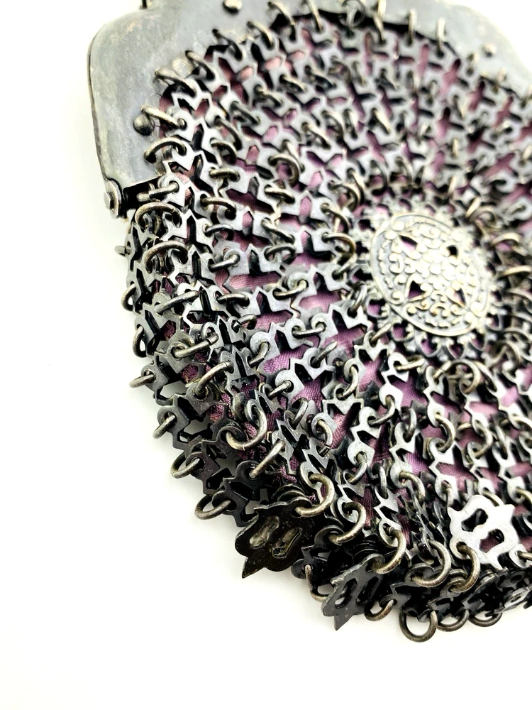 Antique silver-colored chatelaine purse with openwork metal, purple silk lining, fringe, and fleur-de-lis belt clip
