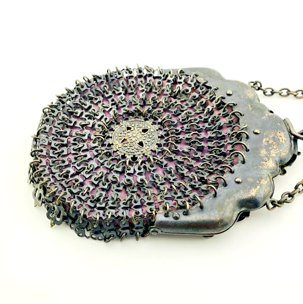 Antique silver-colored chatelaine purse with openwork metal, purple silk lining, fringe, and fleur-de-lis belt clip