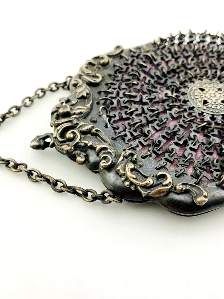 Antique silver-colored chatelaine purse with openwork metal, purple silk lining, fringe, and fleur-de-lis belt clip