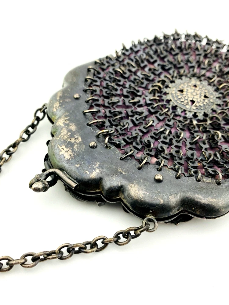 Antique silver-colored chatelaine purse with openwork metal, purple silk lining, fringe, and fleur-de-lis belt clip