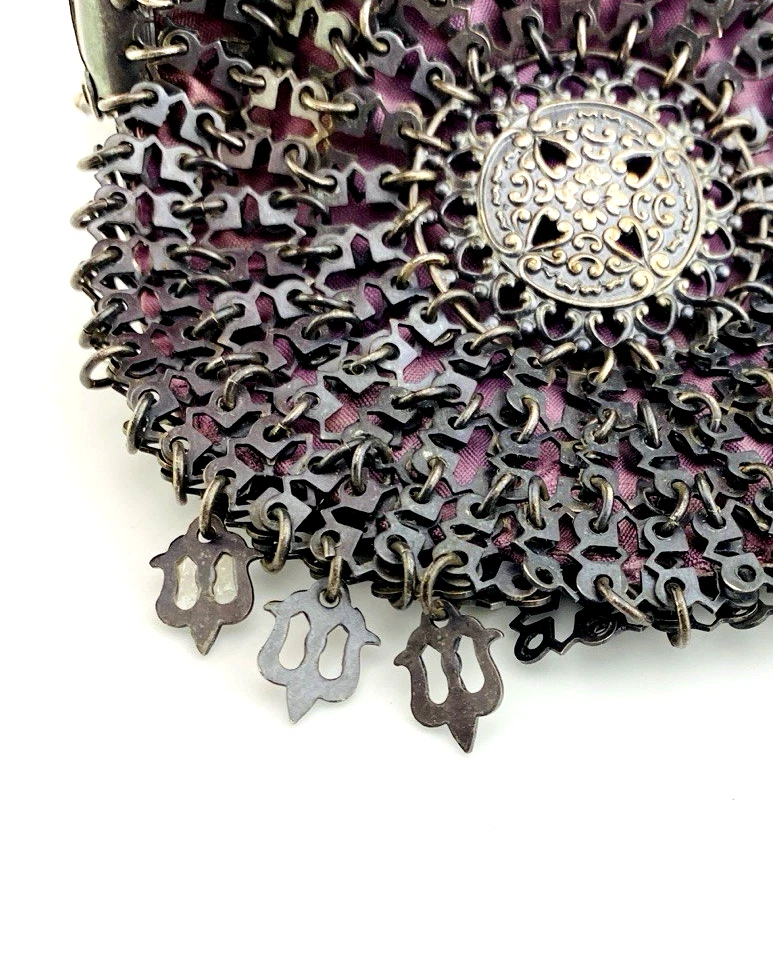 Antique silver-colored chatelaine purse with openwork metal, purple silk lining, fringe, and fleur-de-lis belt clip