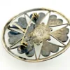 Circular vintage RN Mexican sterling silver brooch pendant with green, blue, and gold dichroic glass cabochon and radial wirework